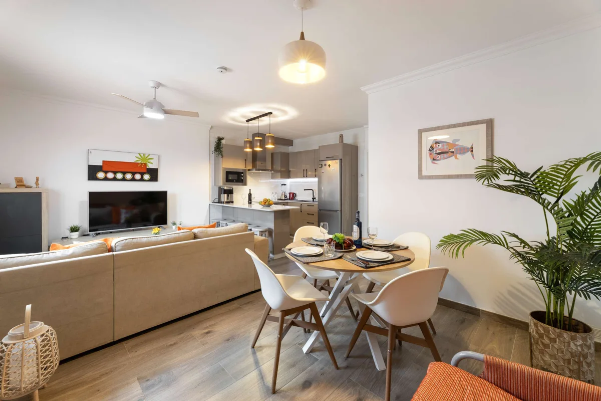 Salón luminoso con comedor, sofá y cocina abierta