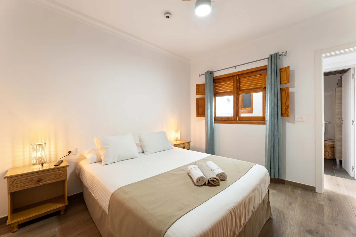 Dormitorio principal con cama de matrimonio y ventana exterior